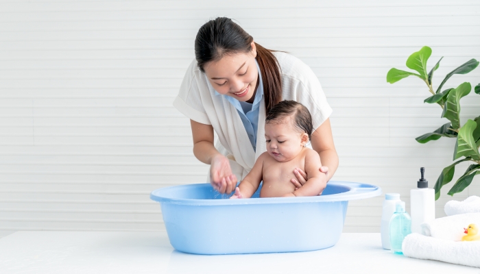 Asian mother Bathing her 7 month old daughter.