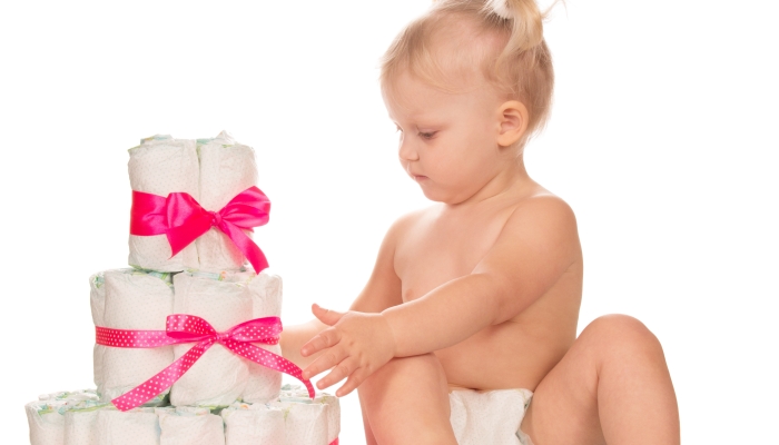 Baby girl with heap of diapers.