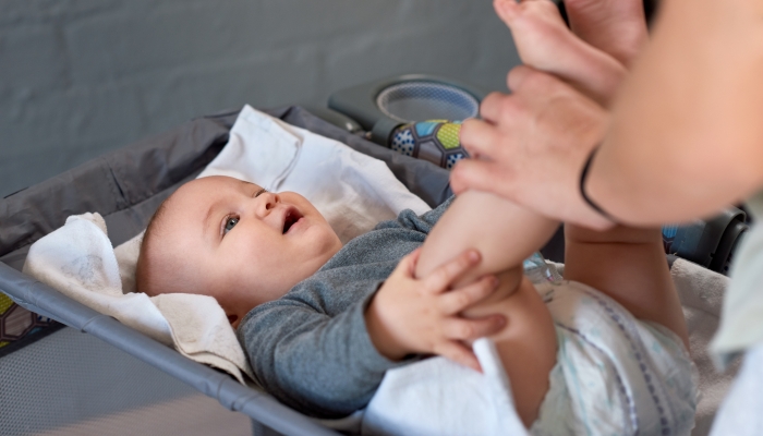 Baby lying on bassinet getting love and attention from mom mother parent.