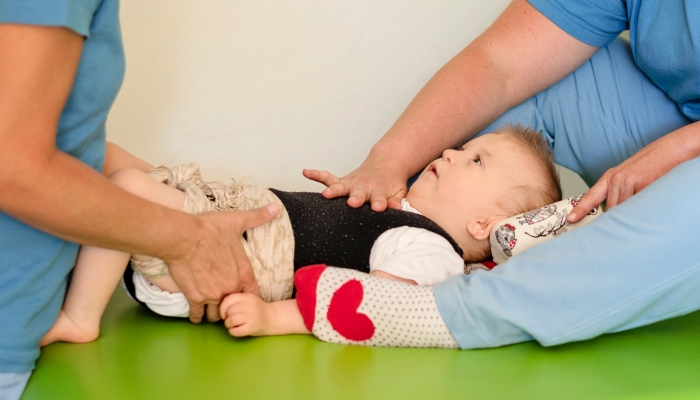 Boy with disability doing exercises with physiotherapist.