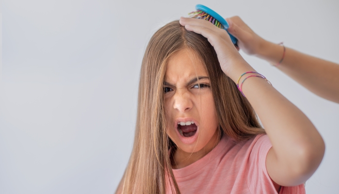 Brushing her hair hurts.