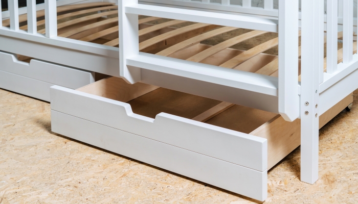 The image of the child's bed, bottom view of the storage drawers.