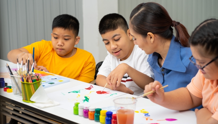 Asian disability boy learning color Painting in classroom with Autism girl in special school with female teacher.