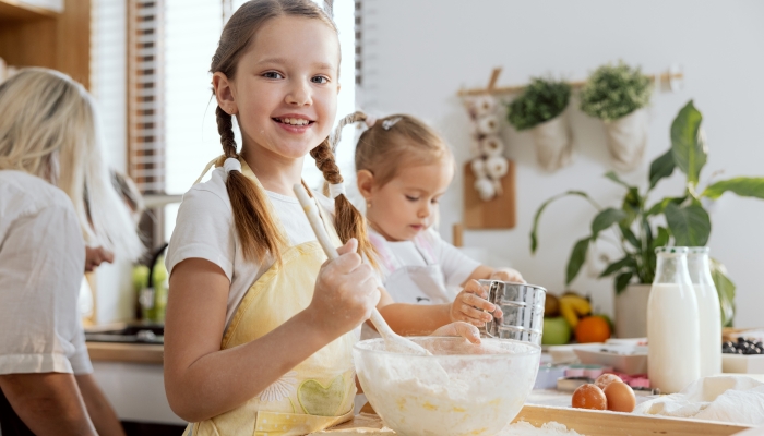 Christmas breakfast adorable granddaughter mixing flour with eggs on wooden flour preparing dough for homemade cookies pizza pasta bread.