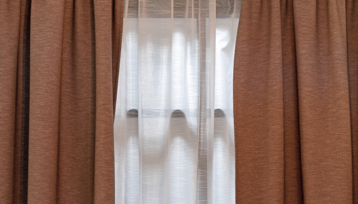 Double-layer curtains in brown blackout fabric and white tulle.