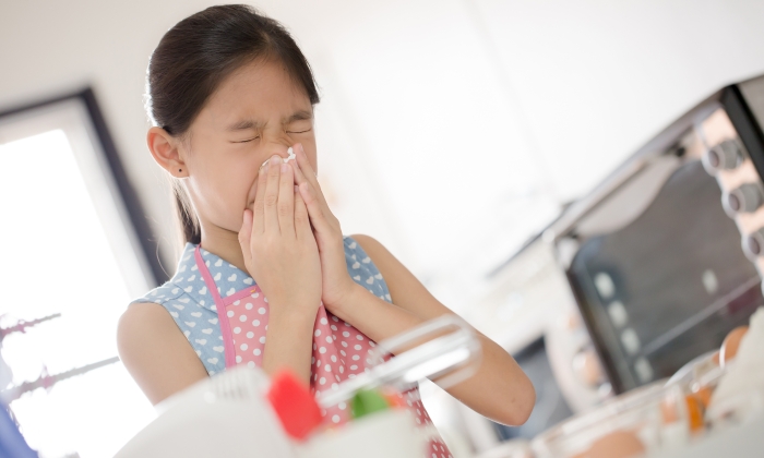 Girl is blowing her nose, allergic to flour.