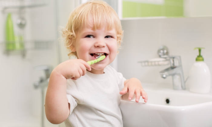 Happy kid brushing teeth.