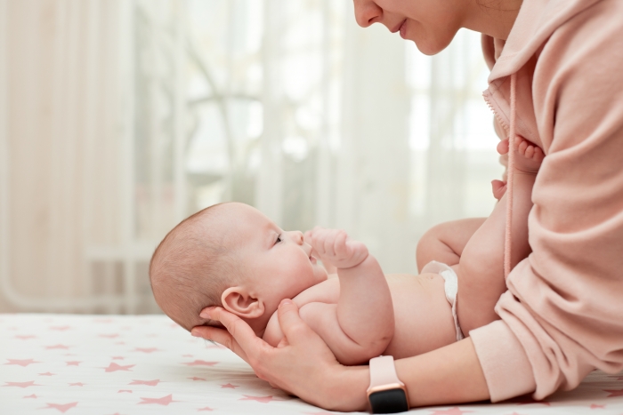 Mother massaging her newborn baby.