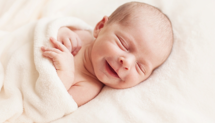 Smiling newborn baby 6 days old.