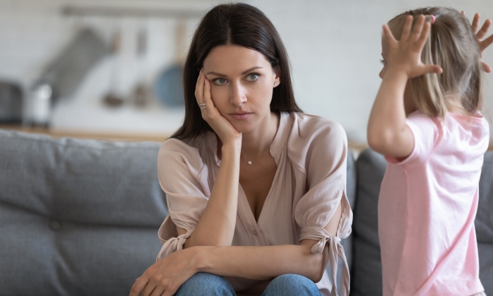 Unhappy mother having problem with noisy naughty little daughter screaming.