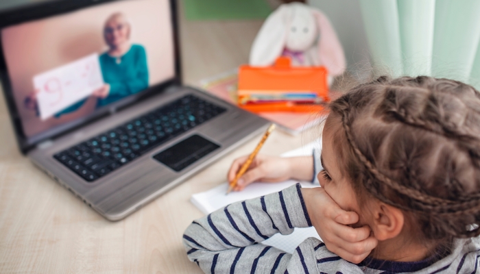 retty stylish schoolgirl studying homework math during her online lesson at home.