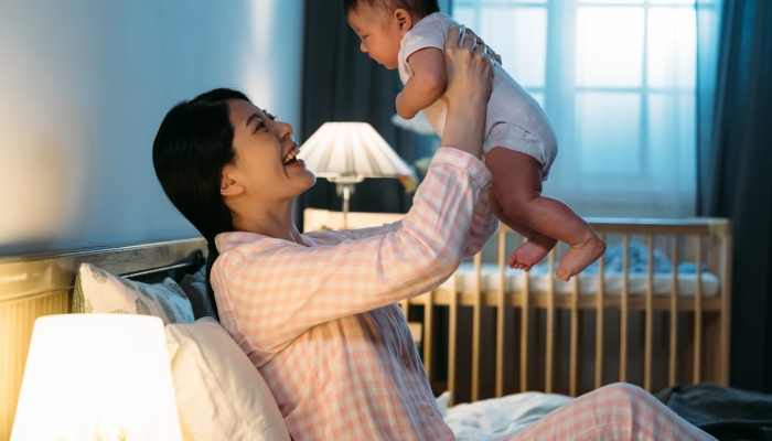 Side portrait cheerful asian mother wearing pajamas.