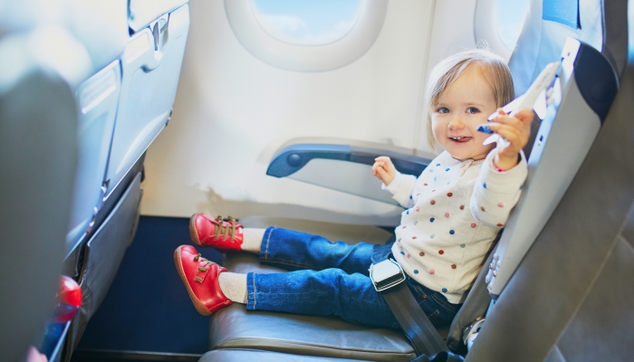 Adorable little toddler girl traveling by plane.