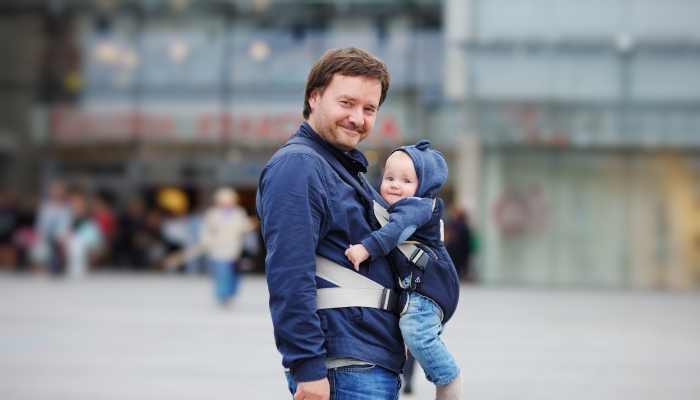 Father and his baby boy in a baby carrier at the big city.