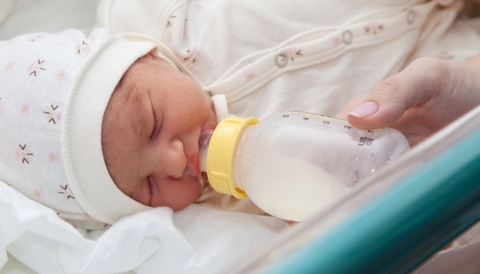 Feeding a newborn baby in maternity hospital.