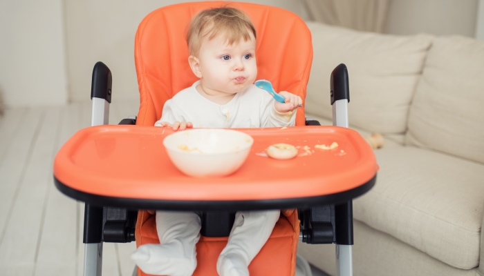 Happy boy in a high chair for feeding.