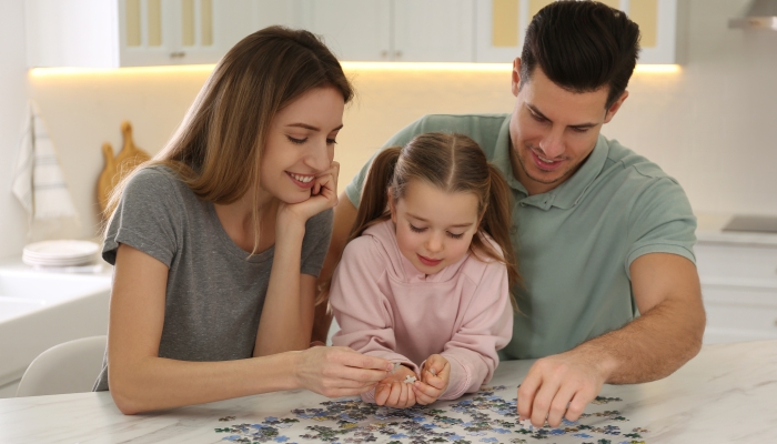 Happy family playing with puzzles at home.