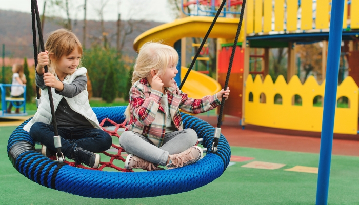 Happy kids having fun on playground outdoors.