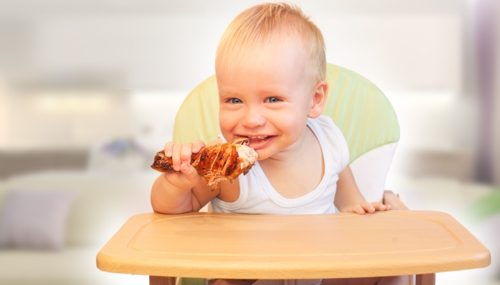 Hungry little boy eat chicken.