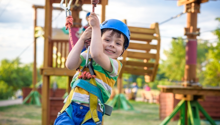 Little cute boy enjoying activity in a climbing adventure park.