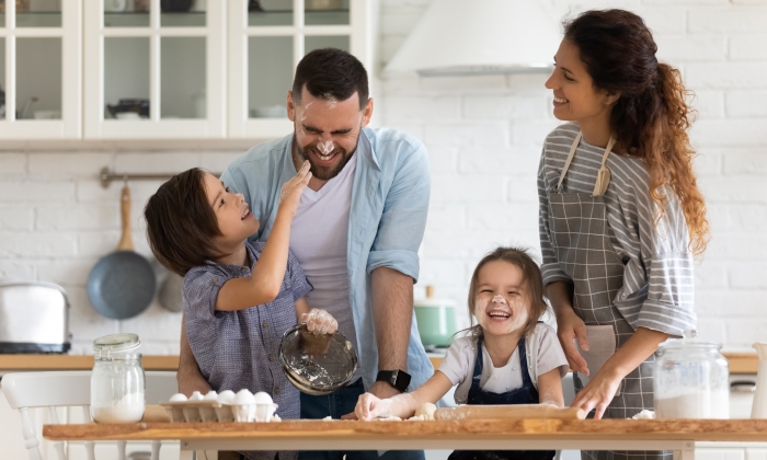 Overjoyed young family with little preschooler kids have fun cooking.