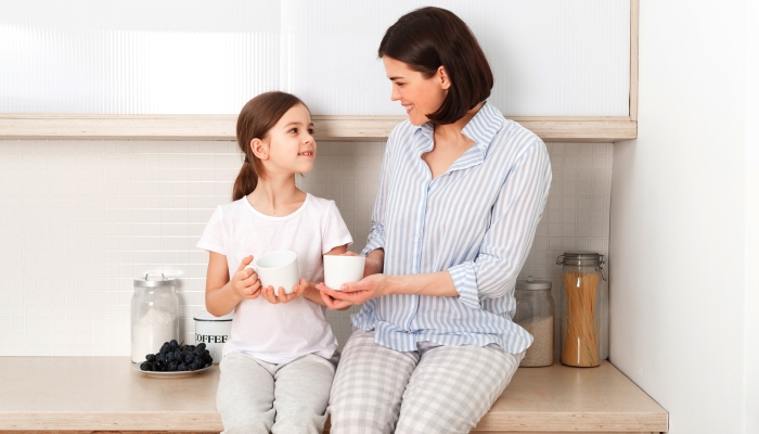 Shot of cheerful mother and daughter sit together.