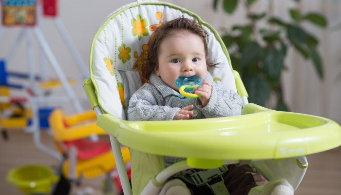 Baby sitting in baby chair and played with toy.