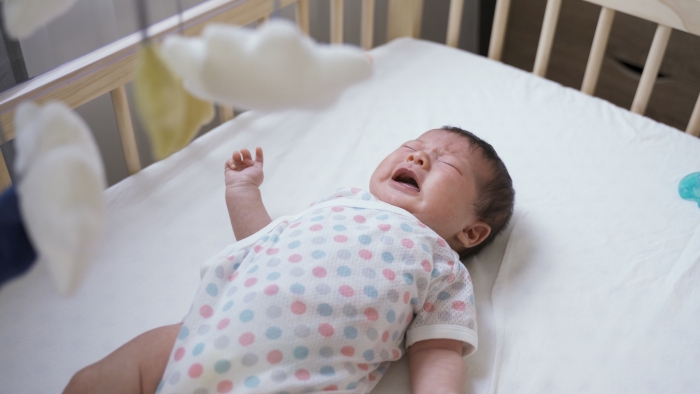 newborn infant lying alone in the baby bed.