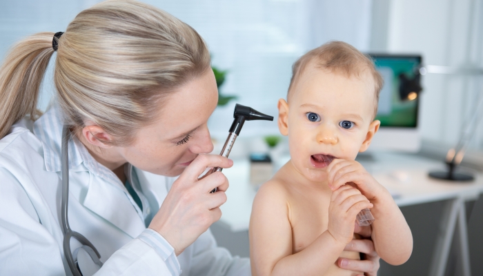 otolaryngologist checking babys ear with otoscope.