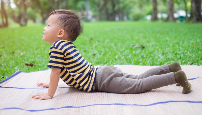 2 year old toddler baby boy child practices yoga.