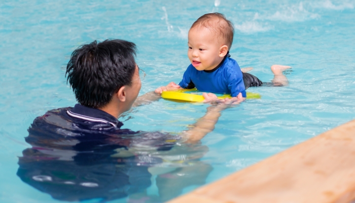 Asian father take cute little asian baby boy child to swimming class.