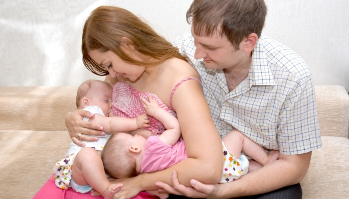 Breast feeding two little sisters twin girls at the same time.