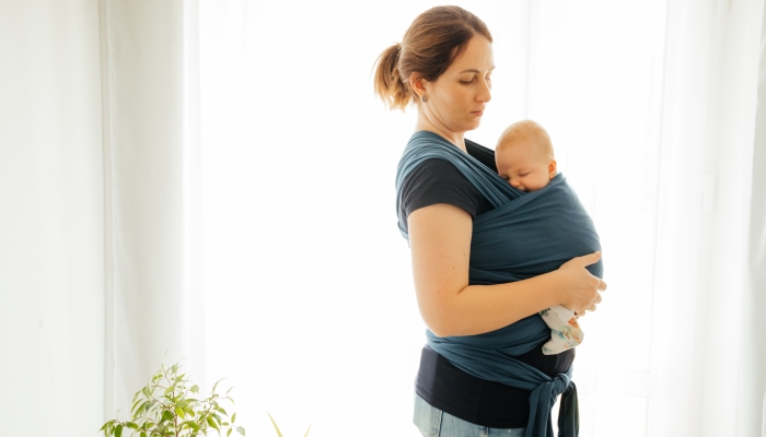 Carrying newborn in baby wrap to comfort him.