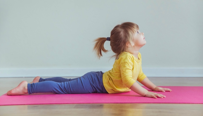 Charming baby doing yoga.