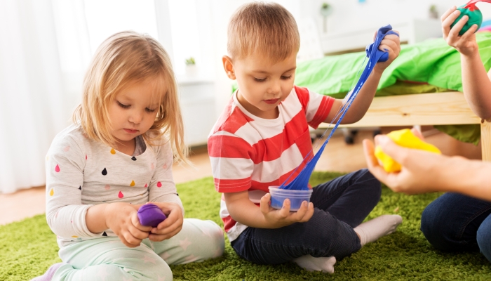 Children playing with modelling clay or slimes at home.