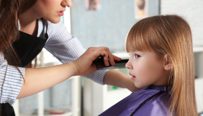 Cute little girl in hairdressing salon.