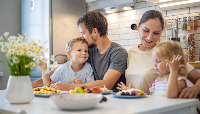 Happy family enjoying weekend breakfast together.