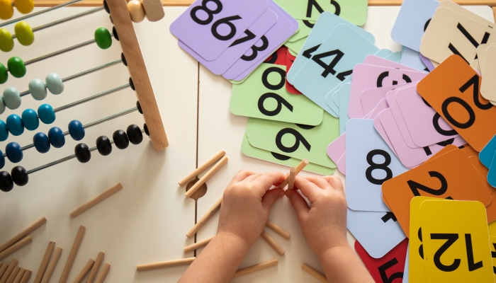 Little caucasian girl studying numbers and math in the classroom.