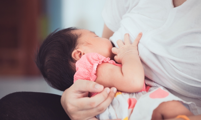 Mother breastfeeding her newborn baby girl.