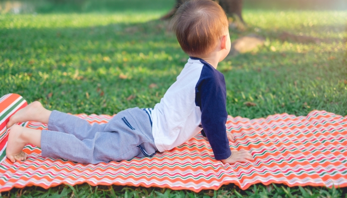 One year old toddler baby boy child practices yoga.