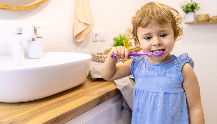 The child brushes his teeth in the bathroom.