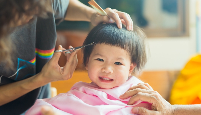 This girl cuts her hair at her home.