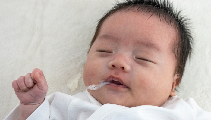 Upper body of a baby wearing milk.