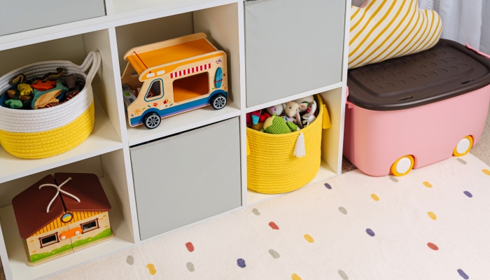 White shelving with colorful storage baskets and boxes with toys.