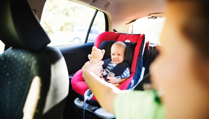 Young mother with her little baby boy in the car.