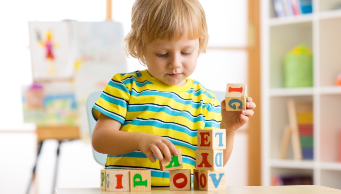 kid playing with block toys and learning letters.