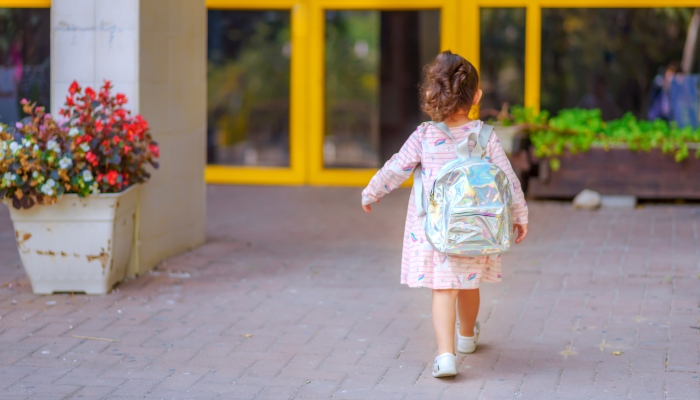 Curly cute little toddler girl back to school.