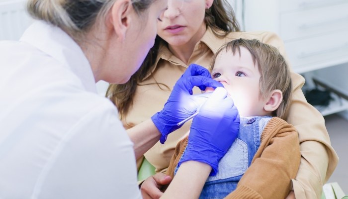Dentist examining boy's teeth in clinic.