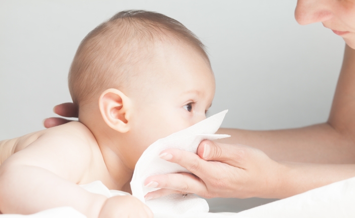 Drooling sick caucasian infant kid with runny nose.