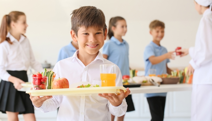 Schoolboy having lunch in school canteen.